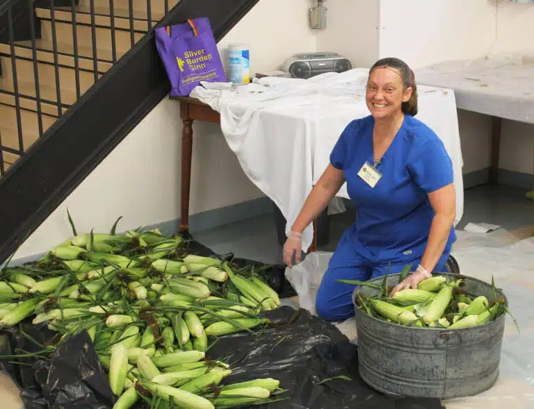 Food Service cook Devin Gibson fills buckets with corn that was brought in from the fields. Food Service cook Devin Gibson fills buckets with corn that was brought in from the fields.