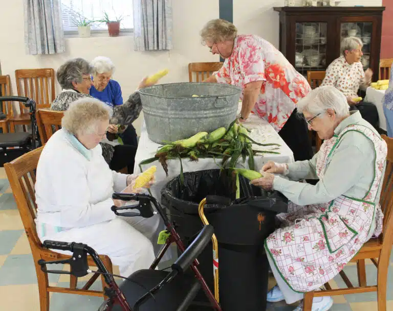 Sister Marie Joseph Coomes, left, and Sister George Mary Hagan discard the corn husks into the trash as Ursuline Associate Suzanne Reiss, standing right, and Sisters Margaret Ann Aull and Elaine Burke fill their bucket. Sister Marie Joseph Coomes, left, and Sister George Mary Hagan discard the corn husks into the trash as Ursuline Associate Suzanne Reiss, standing right, and Sisters Margaret Ann Aull and Elaine Burke fill their bucket.