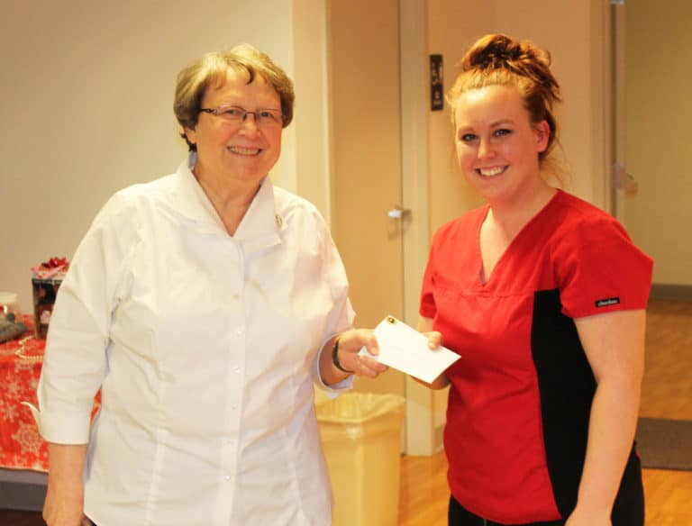 Jessica Cheatham, right, receives her five-year anniversary gift from Sister Amelia Stenger, congregational leader. Jessica works in food service.