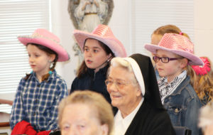 Sister Joseph Angela Boone shares a smile while being surrounded by these pink-hatted cowgirls.