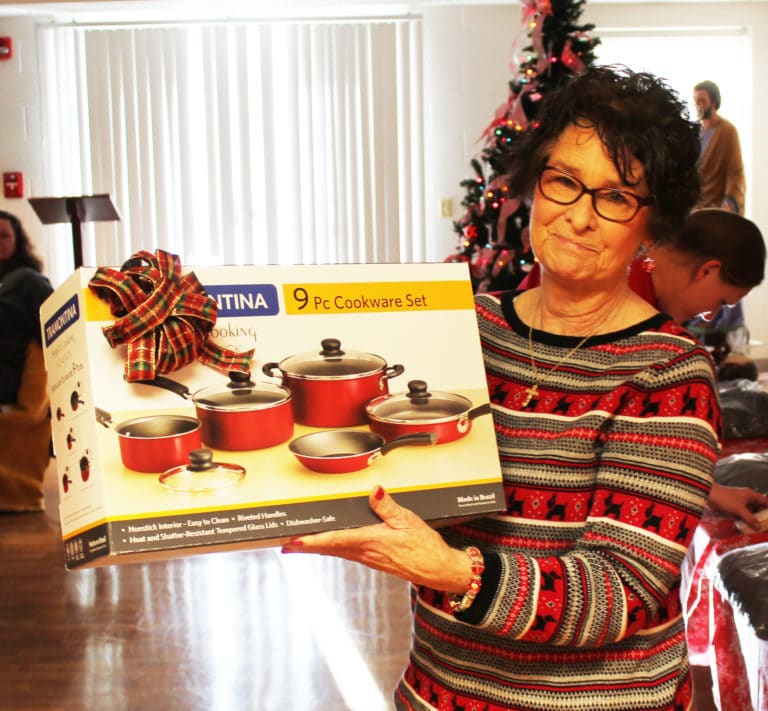 Frances Gaddis shows off the nine-piece set of cookware she won as a door prize.