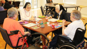 Sister Emma Cecilia Busam, second from right, appears to be discussing some bingo strategy with Sister Pauletta McCarty, second from left. Joining their discussion is Sister Kathy Stein, left, and Sister Celine Leeker.