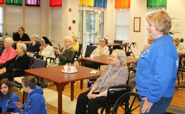 Ursuline Associate Martha Warren, right, principal at Mary Carrico, enjoys the dancing along with Sister Pat Rhoten, center, and other sisters in attendance.