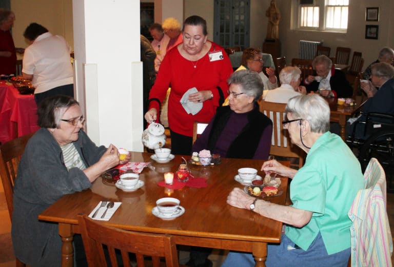 Debbie Dugger, standing, activities coordinator for Saint Joseph Villa, fills Sister Nancy Murphy’s teacup, as Sister Lois Lindle, left, and Sister Sheila Anne Smith enjoy their treats.