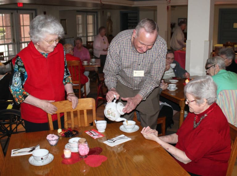 Randy Shelby, director of Motherhouse Services, pours tea for Sister Pat Rhoten, right, who organizes the Gratitude Tea each year. Sister Francis Louise Johnson gives Randy’s pouring technique high marks.