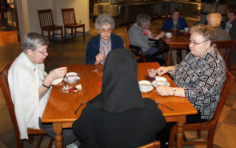 Sister Amanda Rose Mahoney, left, Sister Mary Gerald Payne, center, and Sister Joyce Marie Cecil know the identity of the mystery sister with her back to the camera. Do you? (Hint: It’s Sister Rose Karen Johnson.)