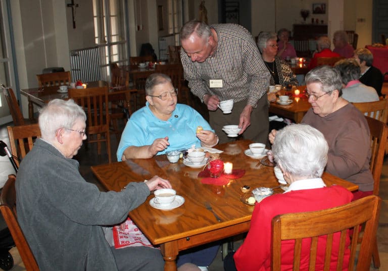Randy Shelby is serving two-fisted as he talks with Sister Kathleen Dueber. Her tablemates are Sister Marie Montgomery, left, Sister Rose Jean Powers, right, and Sister Naomi Aull.
