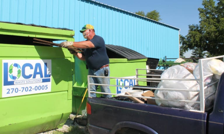 Maintenance worker Bryan Padgett puts cardboard into the Local Waste Solutions dumpster for collection. This pick-up truck gets filled daily with cardboard, paper, plastic and other recyclables on campus.