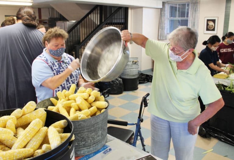 Sister Alicia Coomes, left, and Sister Emma Anne Munsterman empty a pan of sweet corn into a bucket to be taken to the kitchen. The corn is blanched, frozen and served to the Ursuline Sisters and staff throughout the year at mealtimes.