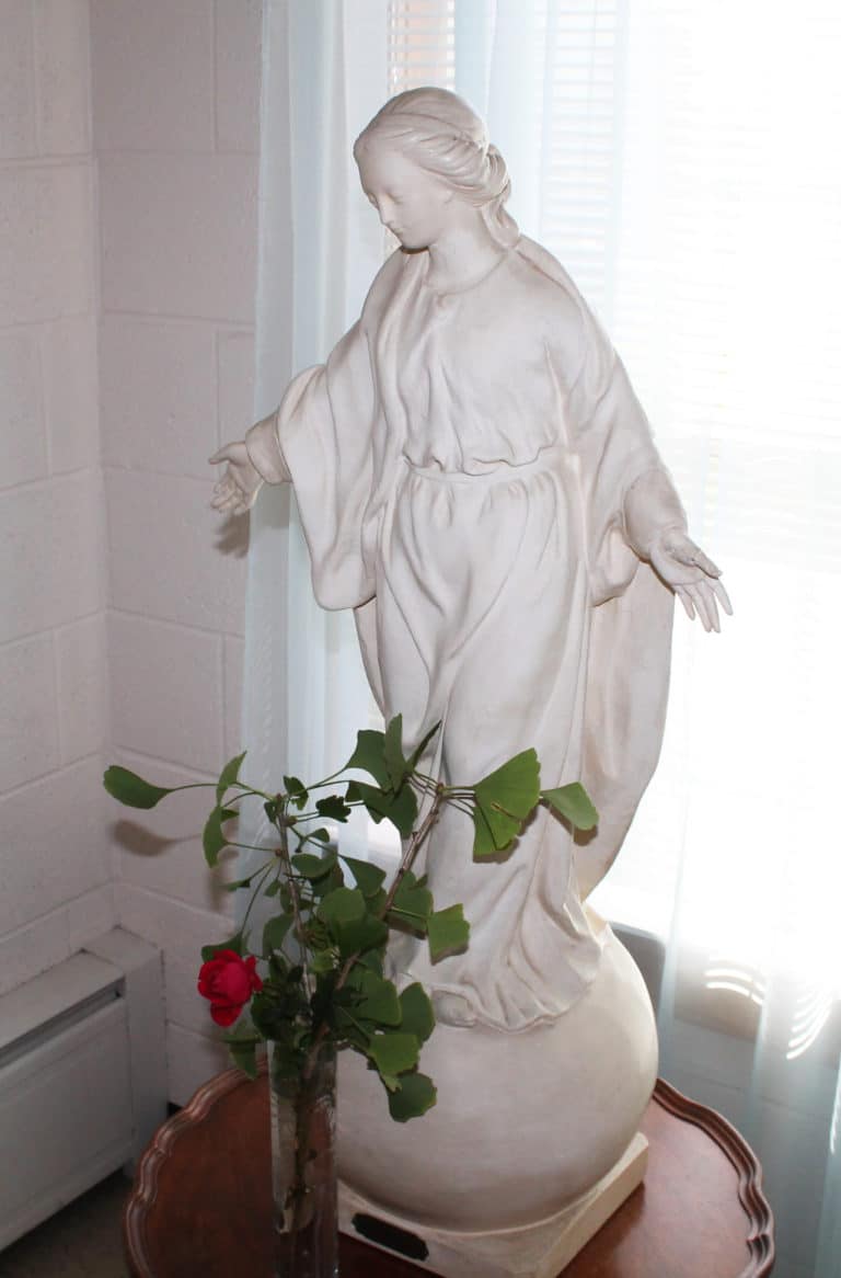 This statue of the Blessed Virgin Mary is believed to be the oldest on campus. According to “Born to Lead,” the book that chronicles Mother Aloysius’ life, this statue was bought by Father Paul Joseph Volk on a trip to Europe in 1884. The Archives staff brought it to Lourdes Hall for the celebration. In front is a sprig from the gingko tree on campus, which Mother Aloysius had planted because it was unique to Kentucky. The rose is because Oct. 1 is also the feast of Saint Therese of Lisieux, “the little flower.”