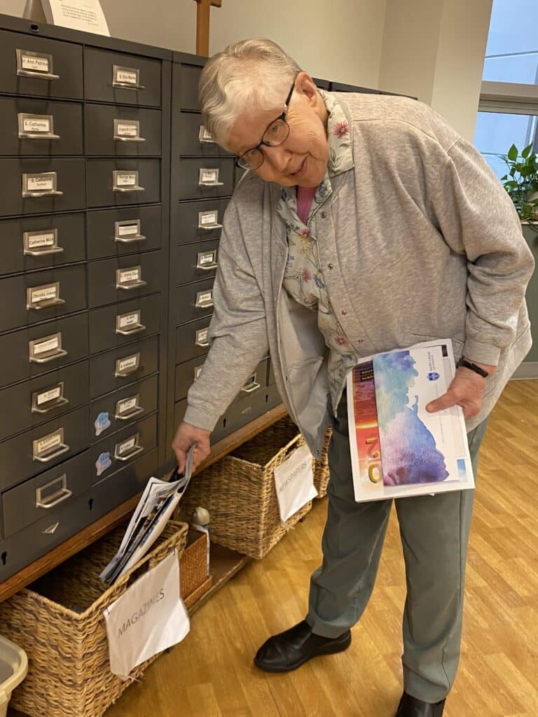 Sister Ruth Gehres puts used magazines in the recycling bin at the Motherhouse. Sister Ruth Gehres puts used magazines in the recycling bin at the Motherhouse.