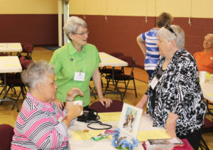 Ursuline Sister Pam Mueller, center, a member of the Associate Advisory Board, talks with Donna Favors, right, and Karen Wells, both of Owensboro, Ky. The two women made their commitments as associates later in the day.