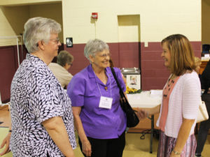 Ursuline Sisters Mary Timothy Bland, left, and Mary Celine Weidenbenner, center, talk with Kim Haire, of Owensboro. Kim made her commitment later in the day.