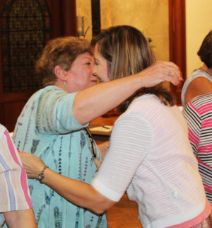 New Associate Kim Haire, right, gets a hug from her contact companion, Associate Joan Perry.