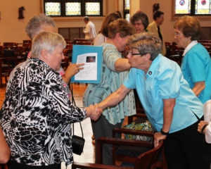 Ursuline Sister Judith Nell Riney, right, a member of the Leadership Council, congratulates Donna Favors on becoming an Associate.