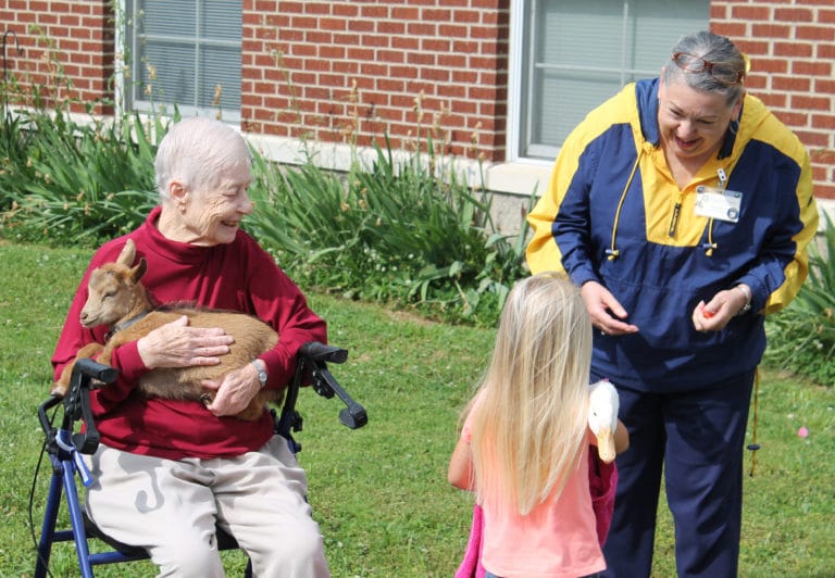 Sister Marcella Schrant, left, holds Flower the goat and talks with Scarlett Blakely, who is holding the family duck while she talks with Debbie Dugger, activities coordinator in the Villa.