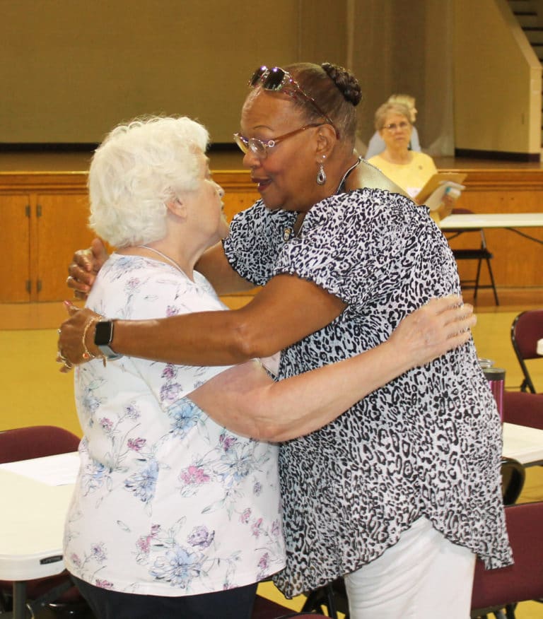 Hugs were plentiful since they were allowed for the first time in more than a year. Here Associate Marian Bennett, left, hugs Associate Joanne Mason.