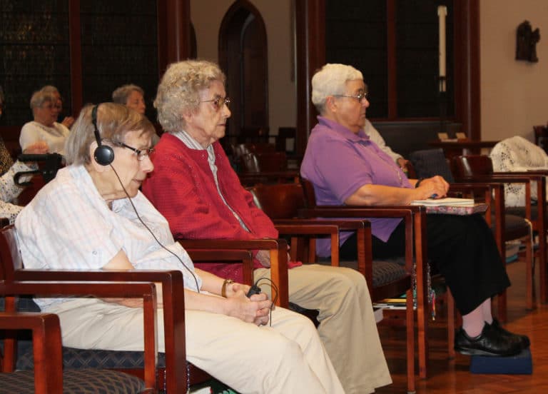 Sister Susanne Bauer, left, Sister Mary Gerald Payne, center, and Sister Ann McGrew listen to Father Hensell.