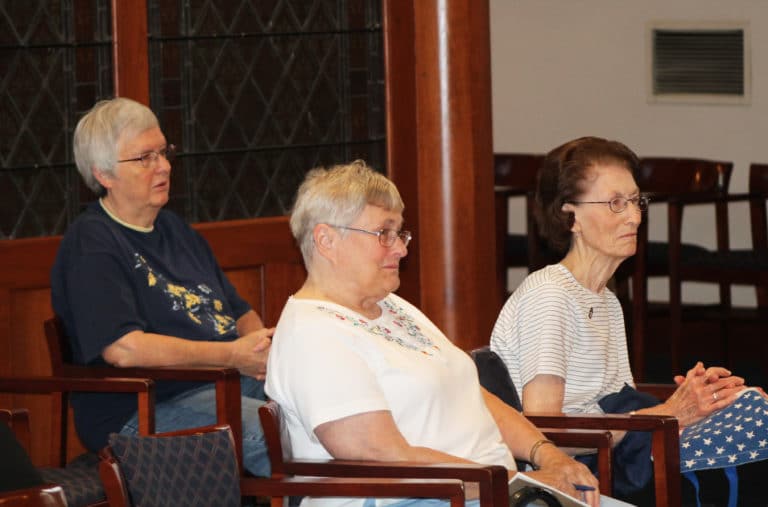 Sister Rita Scott, left, Sister Karla Kaelin, center, and Sister Claudia Hayden follow along with Father Hensell’s talk.