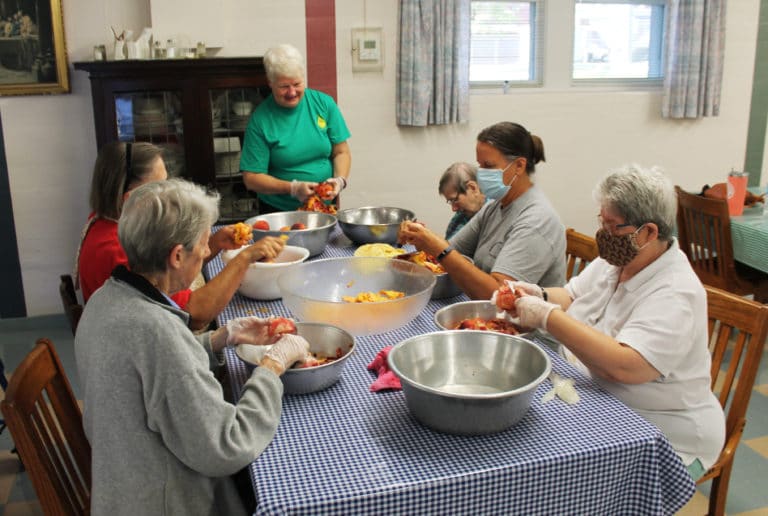 Sister Suzanne Sims stands at the head of the table encouraging her co-workers as they get closer to emptying their peach bowls. Clockwise around the table are Sister Maureen O’Neill, Rosemary Miller, Sister Susanne Bauer, Associate Tina Wolken and Sister Mary McDermott.
