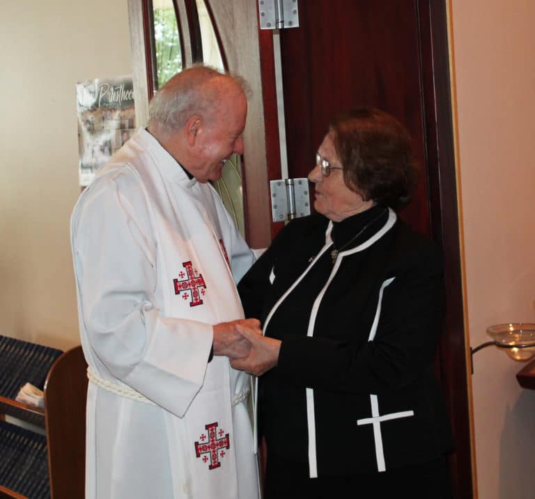 Sister Rosanne is warmly greeted by Father Ed Bradley before Mass.