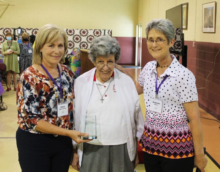 Sister Luisa Bickett, center, poses with her Maple Leaf Award and her nominator, Vickie Bickett Groce, left, and Stephanie Warren, Alumnae Association president.