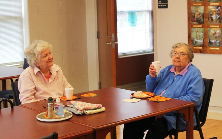 Sister Paul Marie Greenwell, right, says “cheers” as she and Sister Francis Louise Johnson listen to Debbie Dugger.