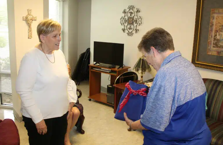 Leanne Robertson, left, outgoing national president of the Kappa Delta Phi sorority, presents Sister Sharon Sullivan, congregational leader, a bag of ‘thank you’ cards that sorority members wrote during their national convention June 26-28, 2025. Leanne Robertson, left, outgoing national president of the Kappa Delta Phi sorority, presents Sister Sharon Sullivan, congregational leader, a bag of ‘thank you’ cards that sorority members wrote during their national convention June 26-28, 2025.