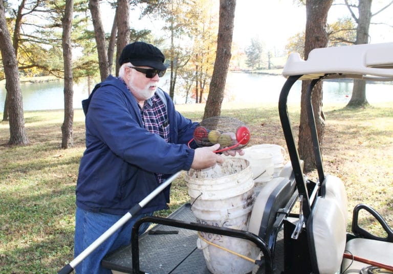 The nut roller picks up walnuts without having to bend over. Here, Father Ray empties walnuts into buckets on the back of his cart.