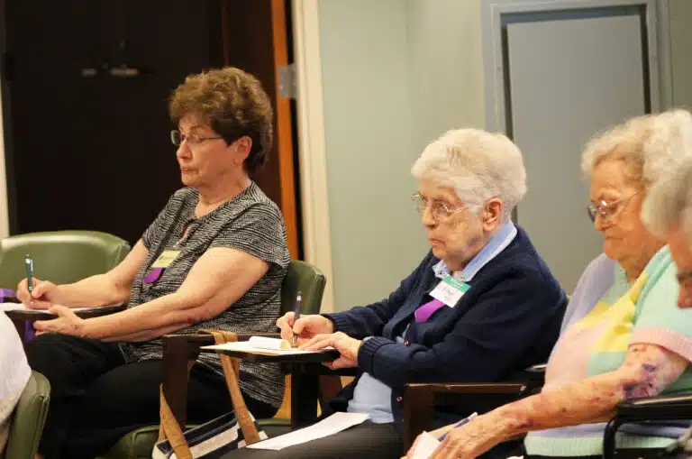 Sister Laurita Spalding, left, and Sister Michael Ann Monaghan, center, take notes, as Sister Pat Rhoten looks on. Novotka asked the Sisters to “create your own canticle, your own poem, your own paragraph about the day.” Sister Laurita Spalding, left, and Sister Michael Ann Monaghan, center, take notes, as Sister Pat Rhoten looks on. Novotka asked the Sisters to “create your own canticle, your own poem, your own paragraph about the day.”