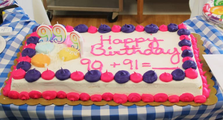 Only in a community of former teachers does a birthday cake require math problems. The cake reads “99 + 91 = ____”