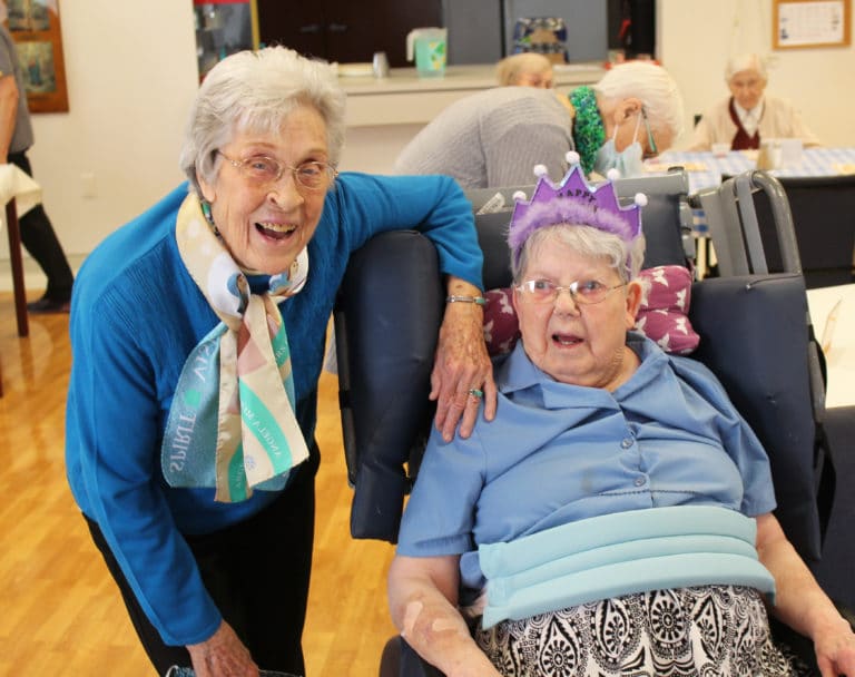 The “birthday girls” smile as the center of attention. Sister Elaine Burke is at left, and Sister Marie Montgomery sports the birthday tiara.