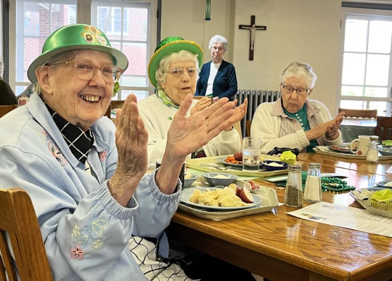 Sister Grace Simpson, left, Sister Michael Ann Monaghan, center, and Sister Ruth Gehres clap for a performance of Sister Mary McDermott showing off her shillelagh skills.