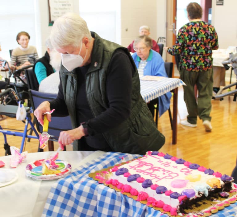 Sister Suzanne Sims, director of local community life for the Sisters at the Motherhouse, and one of the organizers of the party, cuts birthday cake.