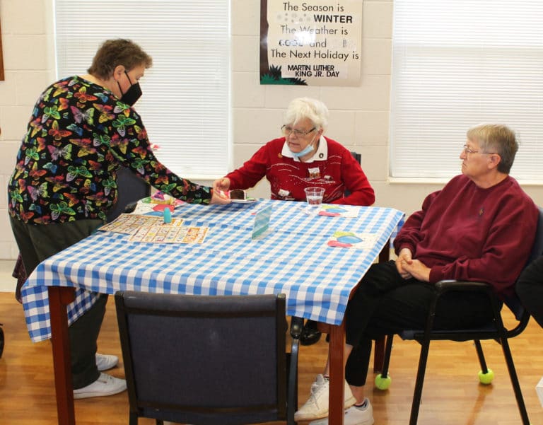 Sister Alicia Coomes hands some cake to Sister Cecelia Joseph Olinger, and Sister Emma Anne Munsterman.