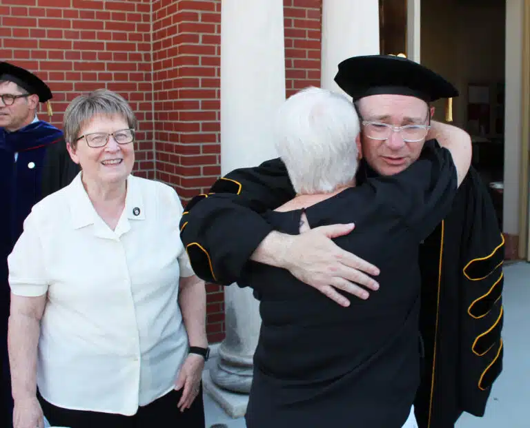 Sister Suzanne Sims hugs Madison Silvert following the ceremony, as Sister Amelia Stenger looks on. Sister Suzanne Sims hugs Madison Silvert following the ceremony, as Sister Amelia Stenger looks on.