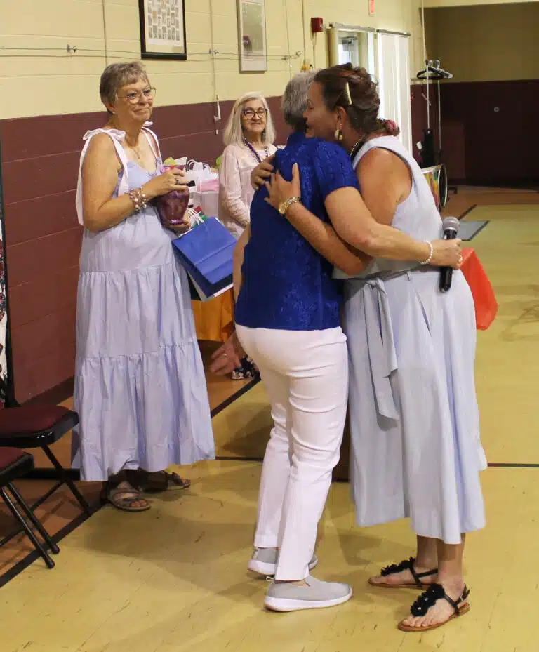 Elaine Clouse A’77, right, hugs Stephanie Warren, as Paula Chandler Gray prepares to present her with a vase. Elaine, who is retired from working at the Mount, was honored for her many years of helping with Alumnae Weekend. Elaine Clouse A’77, right, hugs Stephanie Warren, as Paula Chandler Gray prepares to present her with a vase. Elaine, who is retired from working at the Mount, was honored for her many years of helping with Alumnae Weekend.