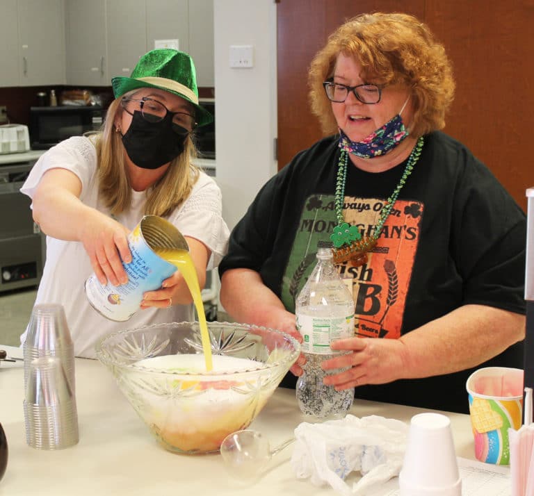 Finance office staff members Sherry Newton, left, and Tammy Vernon Brown prepare the punch for the party in Saint Joseph Villa.