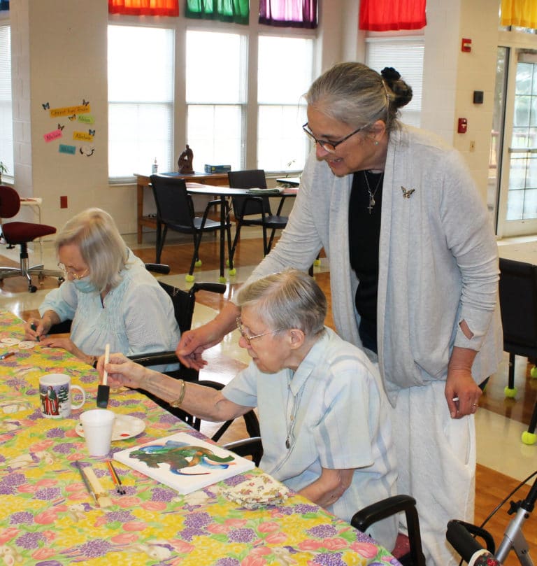 Sister Larraine smiles as Sister Amanda Rose Mahoney demonstrates her abstract painting.