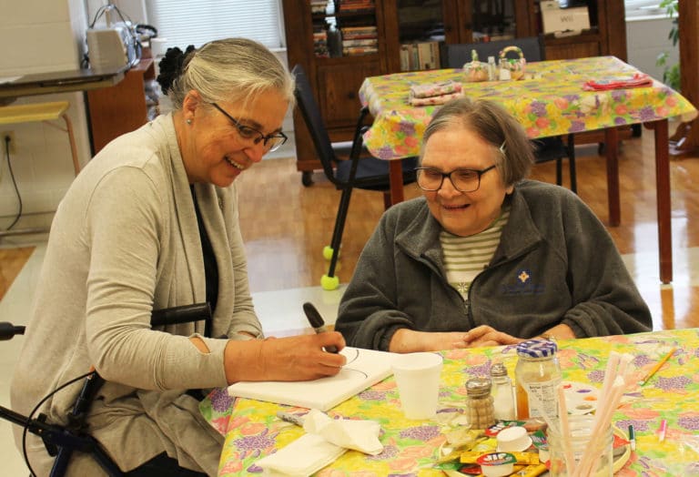 Sister Larraine, left, and Sister Lois Lindle share a laugh as Sister Larraine draws a butterfly for Sister Lois to paint.