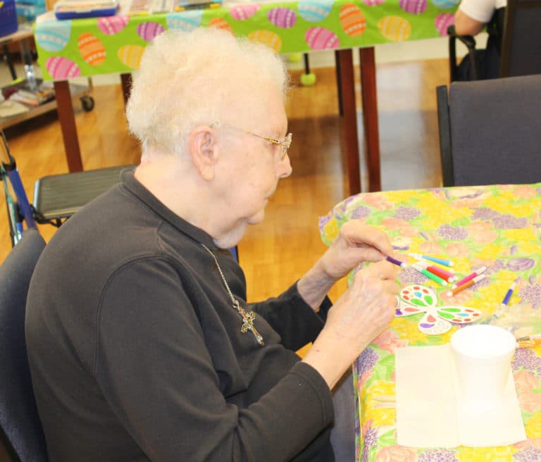 Sister Mary Agnes VonderHaar mixes the colors she wants for her butterfly.