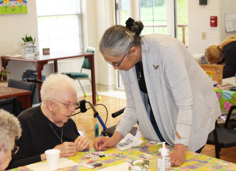 Sister Larraine helps Sister Mary Agnes VonderHaar attach a piece to her butterfly.
