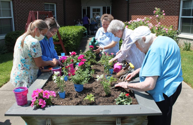 It was a warm and sunny day for the Sisters to plant their flowers. Around the raised bed from left are Terry Owen, Sister Paul Marie Greenwell, Sister Alicia Coomes, Sister Mary Gerald Payne and Sister Catherine Kaufman.