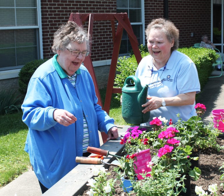 Sister Paul Marie Greenwell, left, and Sister Alicia Coomes share a laugh before Sister Paul Marie watered the flowers.