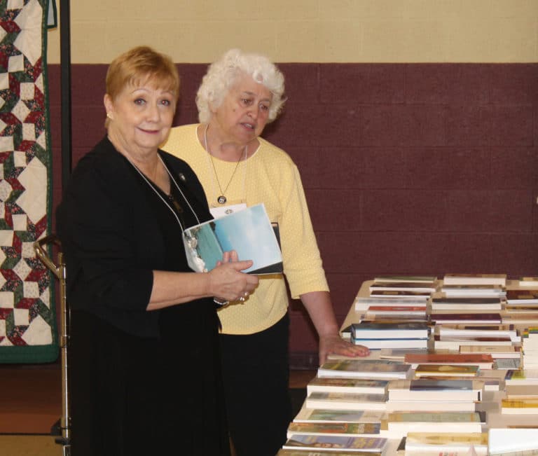 Associates Bonnie Marks, left, and Marian Bennett look over the free book table.
