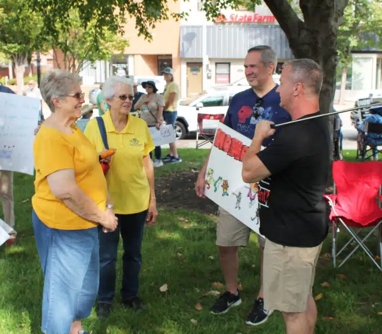 Sister Betsy Moyer, left, and Sister Barbara Jean Head talk with two other people who were attending the rally.