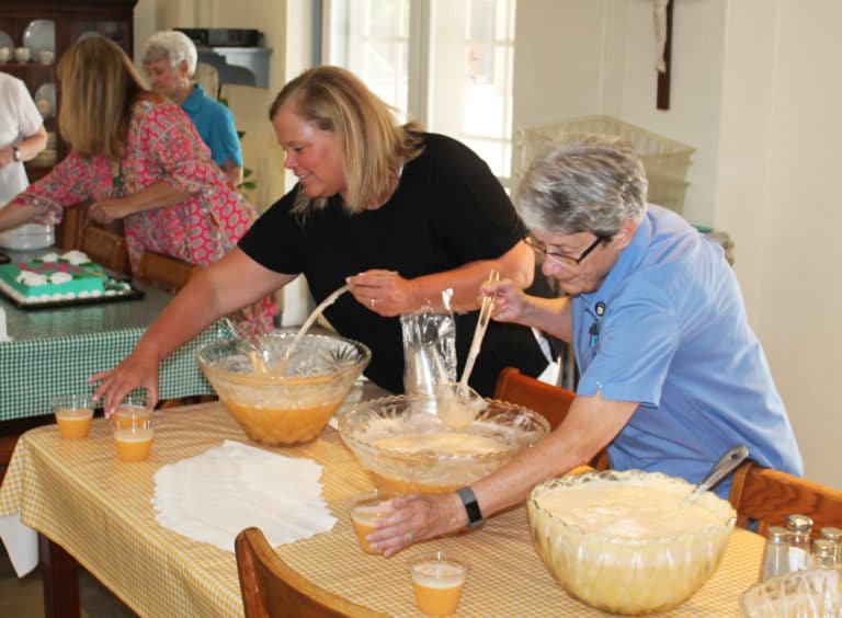 Rachel Phillips, left, who works in human resources, serves punch along with Sister Judith Nell Riney.