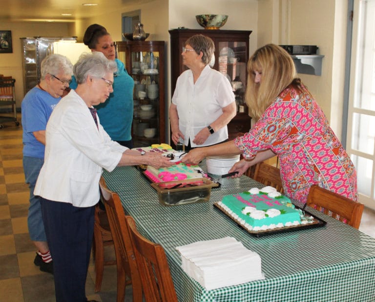 Dee Dee Jackson, right, director of human resources, hands a piece of cake to Sister Nancy Murphy in the Maple Mount dining room, as Sister Cecelia Joseph Olinger waits in line. Also in the background are Trish Durham, of the food services staff, and Sister Amelia Stenger.