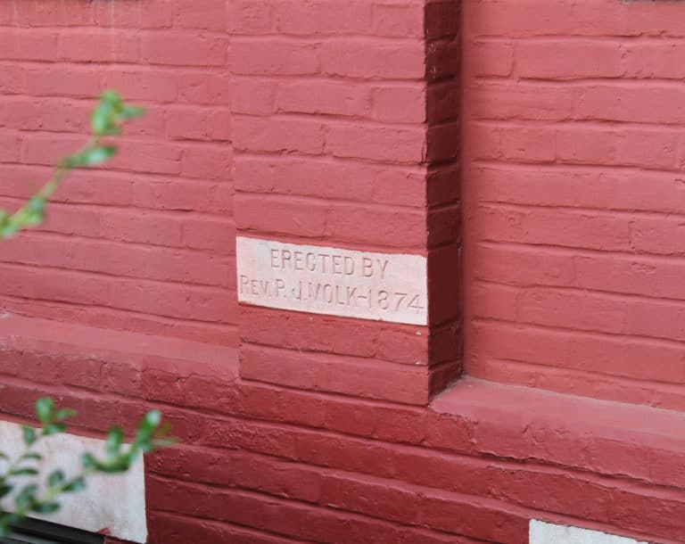 This brick, mostly hidden behind bushes, commemorates the original building erected by Father Paul Joseph Volk in 1874. Since then, additions were constructed in 1882, 1904, 1962 and 1998.