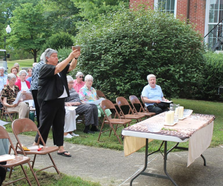 Sister Michele Ann Intravia carries a bowl with incense to the table. Sister Pam Mueller lighted the incense with the prayer “Let our prayers of gratitude rise like incense.”